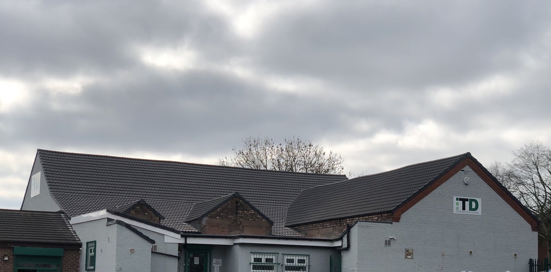 A large single-storey building re-roofed in dark tiles